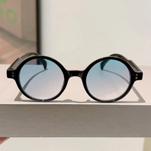 Detail view of retro round sunglasses with black frames and blue gradient lenses