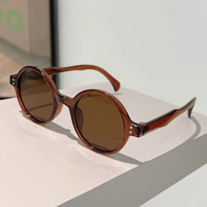 Detail shot of vintage round amber frames with silver metal rivets and brown lenses