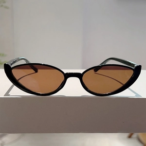 Close-up of cat-eye sunglasses with glossy black frames and tinted brown lenses