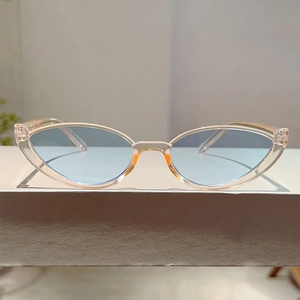 Detail view of cat eye sunglasses with transparent light blue lenses and retro frame