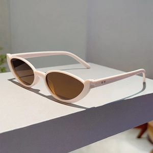 Detail of trendy cat-eye sunglasses with cream white frame and silver metal accents
