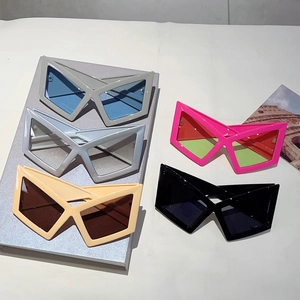 Futuristic geometric X-frame sunglasses in five assorted colors displayed on a podium