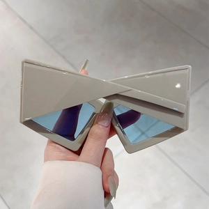 Detail view of beige geometric futuristic sunglasses with light blue lenses and chunky frame