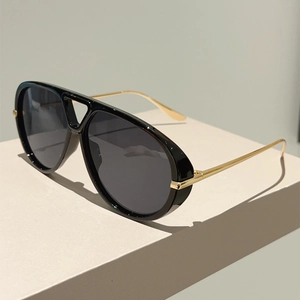 Détail de lunettes aviateur avec branches dorées et design moderne à double pont nasal