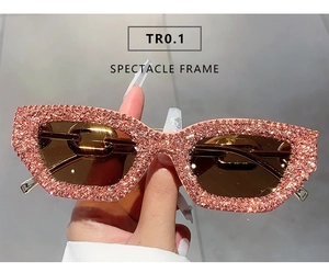 Detailansicht der rosa Sonnenbrille mit funkelnden Strasssteinen und Kettenbügeln