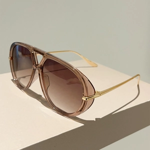 Détail de lunettes aviateur surdimensionnées avec verres dégradés et branches dorées