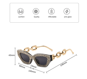 Detailansicht der Cateye-Sonnenbrille mit Strassbesetzten Rahmen und goldener Kettenglieder