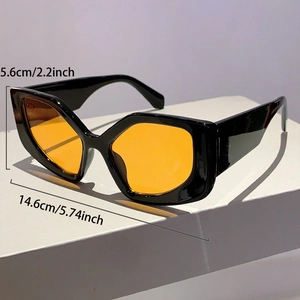 Detail view of bold cat-eye sunglasses with thick black frames and yellow lenses