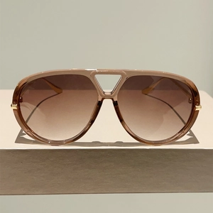 Détail de lunettes aviateur avec verres dégradés marron et accents en métal doré