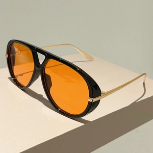 Détail de lunettes aviateur vintage avec verres orange et branches en métal doré