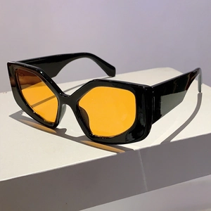 Close-up of geometric cat eye sunglasses with black frames and orange lenses