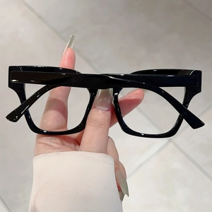 Close-up of stylish black thick-frame cat-eye glasses showing frame texture and design