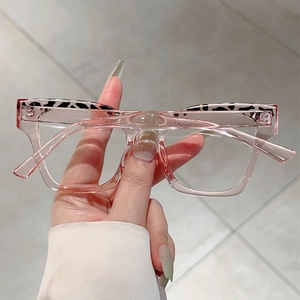 Close-up of pink transparent square glasses frame with unique top pattern detail