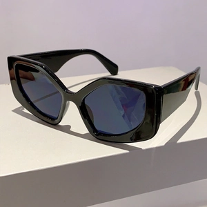Detail view of black geometric cat-eye sunglasses with thick frames on white display