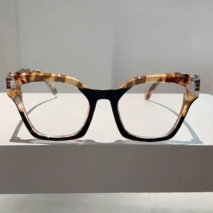 Detail of cat-eye eyewear showing tortoise shell texture and silver hinge accent