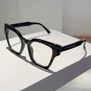 Detailed view of black cat-eye glasses frame on a minimalist geometric white stand