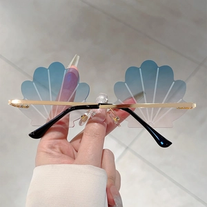 Detail of rimless shell shaped sunglasses with blue pink gradient lenses and gold metal frame