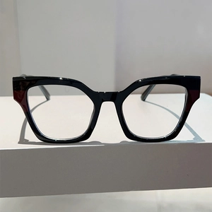 Macro view of geometric black cat-eye glasses frame on a minimalist white stand