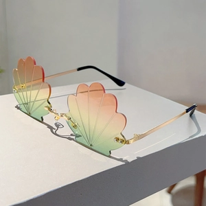 Detailed view of rimless shell shaped sunglasses with gradient lenses and gold metal frames