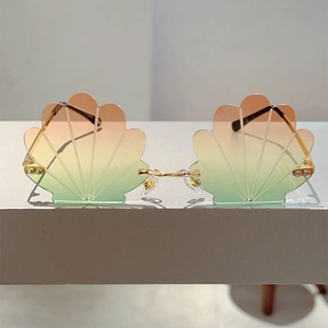 Detail of rimless shell shaped sunglasses with orange to green gradient lenses