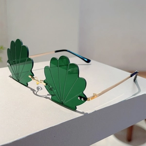 Detailed close-up of emerald green scallop shell lenses with thin gold metal frame sunglasses