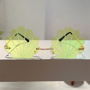 Macro shot of shell-shaped light green lenses with gold metal frame details