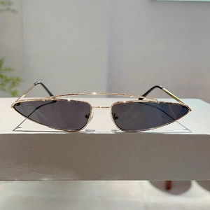 Detailed view of trendy gold metal triangle sunglasses with double bridge on a white stand
