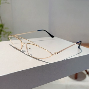 Detailed close-up of slim gold metal double bridge frames on minimalist triangle sunglasses
