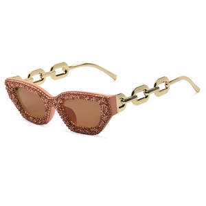 Rosa Katzenaugen-Sonnenbrille mit Strasssteinen und goldener Kettengestaltung in Seitenansicht