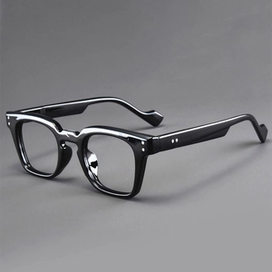 Macro detail of glossy black square frame glasses with silver rivet embellishments