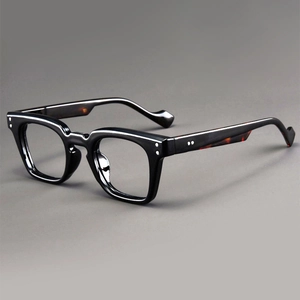 Detail of vintage square glasses frame featuring silver rivets and tortoiseshell temples
