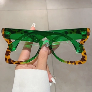 Close-up of stylish oversized butterfly frames with green and leopard print splicing