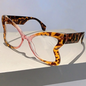 Detail of tortoiseshell cat-eye frames with pink gradient bridge on display stand