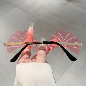 Detail of pink ginkgo leaf shaped frameless lenses with gold metal frame sunglasses