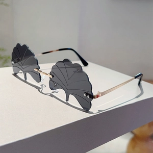 Detail view of rimless ginkgo leaf shaped sunglasses with gold metal temples
