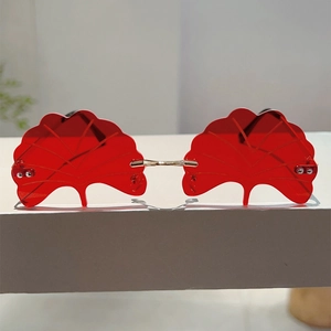 Close-up of red ginkgo leaf shaped rimless lenses with intricate vein texture detail