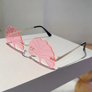 Close-up of pink ginkgo leaf shaped rimless sunglasses with slender gold metal temples