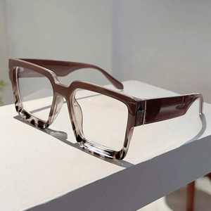 Detail of square gradient frame glasses with tortoiseshell texture on white podium
