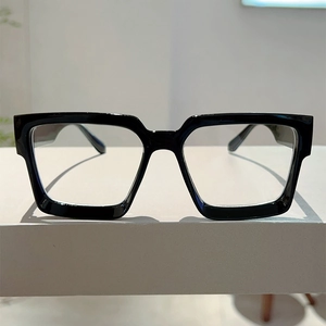 Detail of classic black square frame glasses with wide temples on a minimalist stand