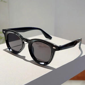 Detail of silver arrow metal rivets on vintage black round frame sunglasses