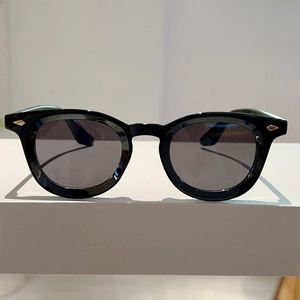 Close-up of vintage round black sunglasses with iconic silver diamond-shaped rivets