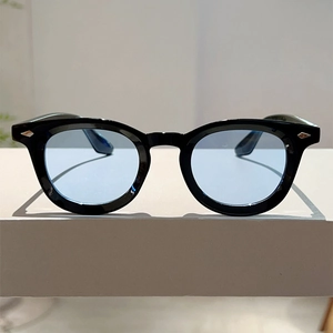 Close-up of black round frames with silver diamond studs and light blue lenses