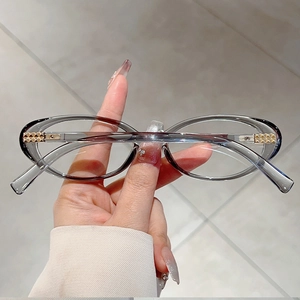 Detail of grey oval glasses frame with gold diamond pattern metal hinge decoration