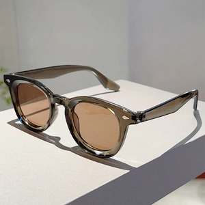 Detail of vintage round sunglasses featuring grey transparent frames and silver rivets