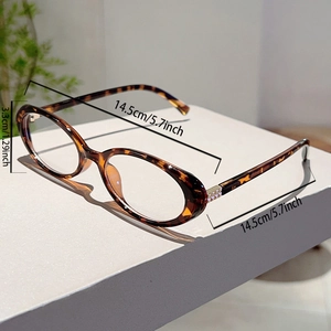 Detail view of tortoiseshell oval frame glasses with metal hinge and dimension markings