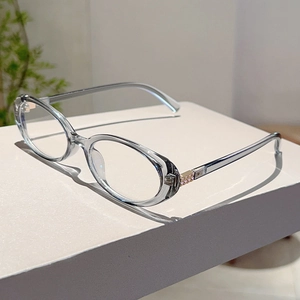 Detail view of oval transparent grey resin frame with subtle light gold metal hinges