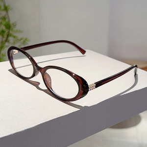 Detailed side view of vintage oval eyewear with amber texture and gold metal accents