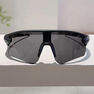 Detail view of sport sunglasses with black frame and grey lens on a white stand