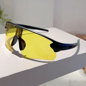 Detail of yellow cycling sunglasses with black streamlined frame on a white display pedestal