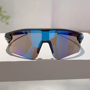 Close-up of blue mirrored lenses on aerodynamic black frame sports cycling sunglasses
